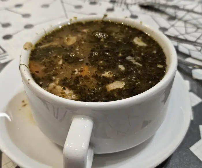 Zupa w białej filiżance z uszkiem